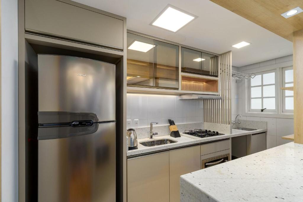 a kitchen with a stainless steel refrigerator at Apto bem no Centro 2 dorm by Achei Gramado in Gramado