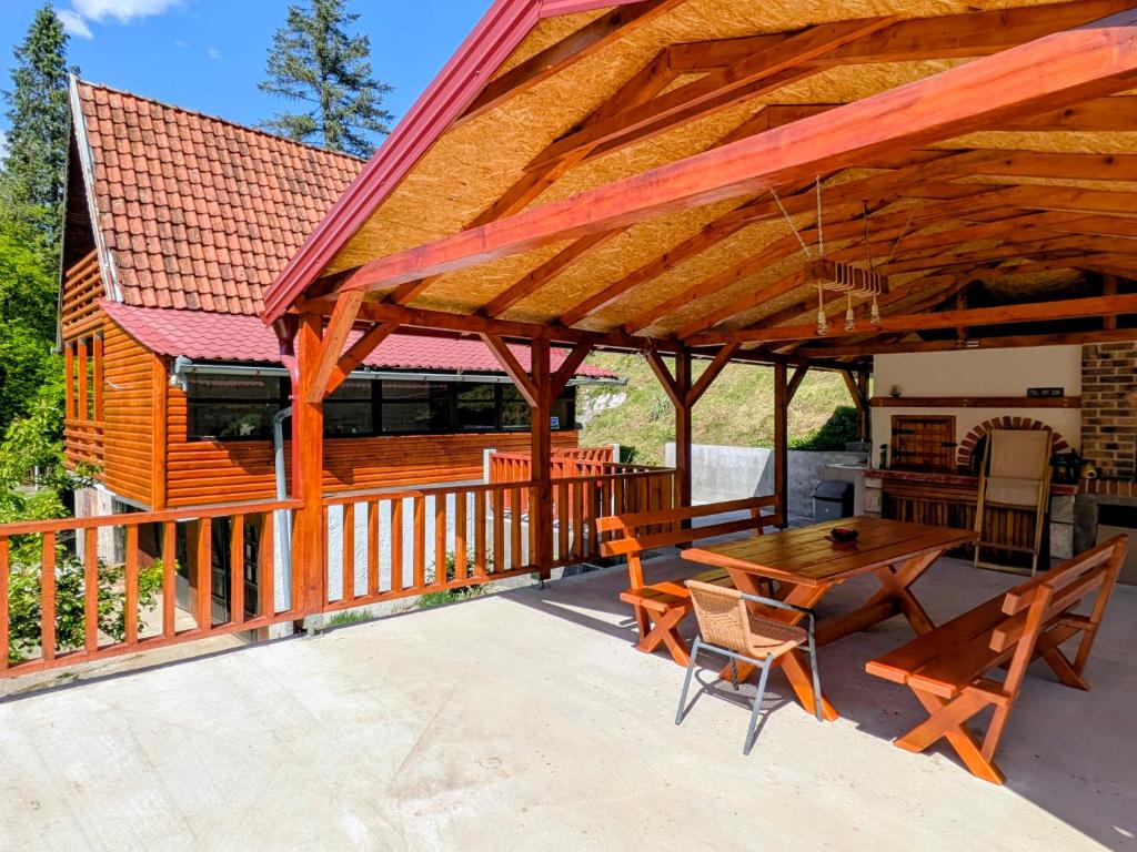 a large wooden pavilion with a wooden table and chairs at KOPILOVE in Foča