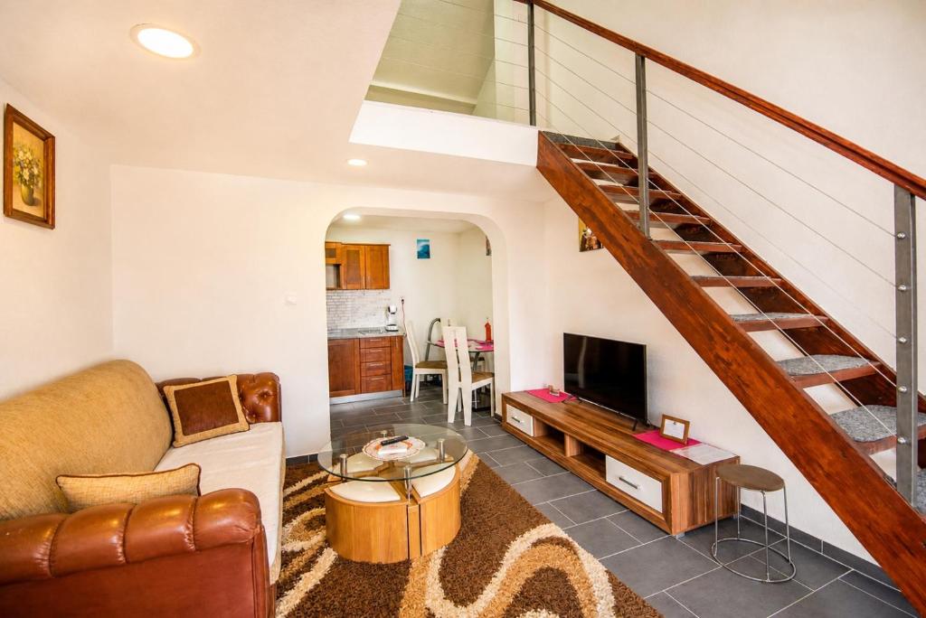 a living room with a couch and a staircase at Apartments Duplex Oliva in Trebinje