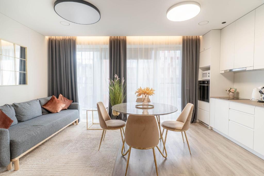 a living room with a couch and a table at Skylum 17th Floor Apartment in Vilnius