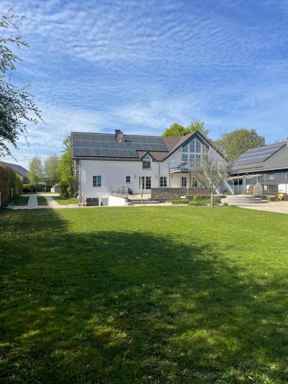 a large white house with a large yard at Gladgîte in Waimes