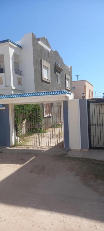 a house with a fence in front of it at Maison à louer in Chebba