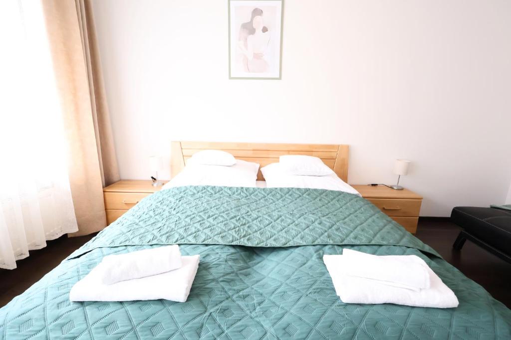 a bedroom with a green bed with white pillows at Appartementhaus Ludwig in Mörbisch am See