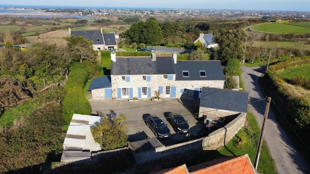 an aerial view of a large white house with three cars at Kazh bihan in Guissény