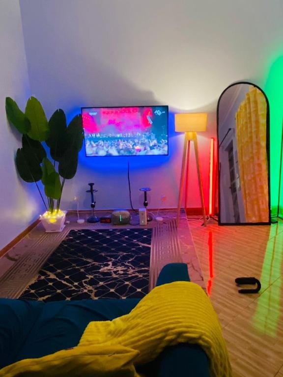 a living room with a tv and a couch and a lamp at The calm Stay in Nkoanrua