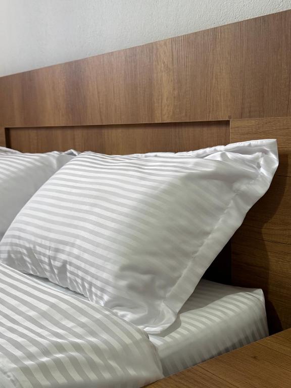 a white pillow sitting on top of a bed at Bloom House Përmet in Përmet