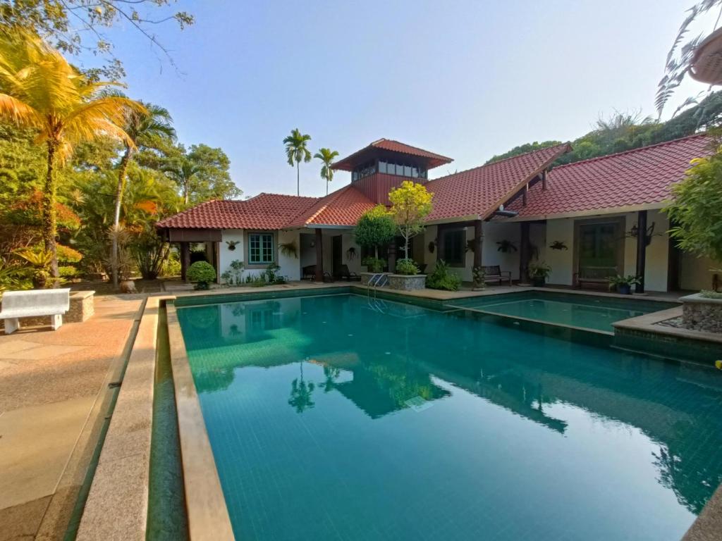 a swimming pool in front of a house at Golden Snapper Guest House in Yan