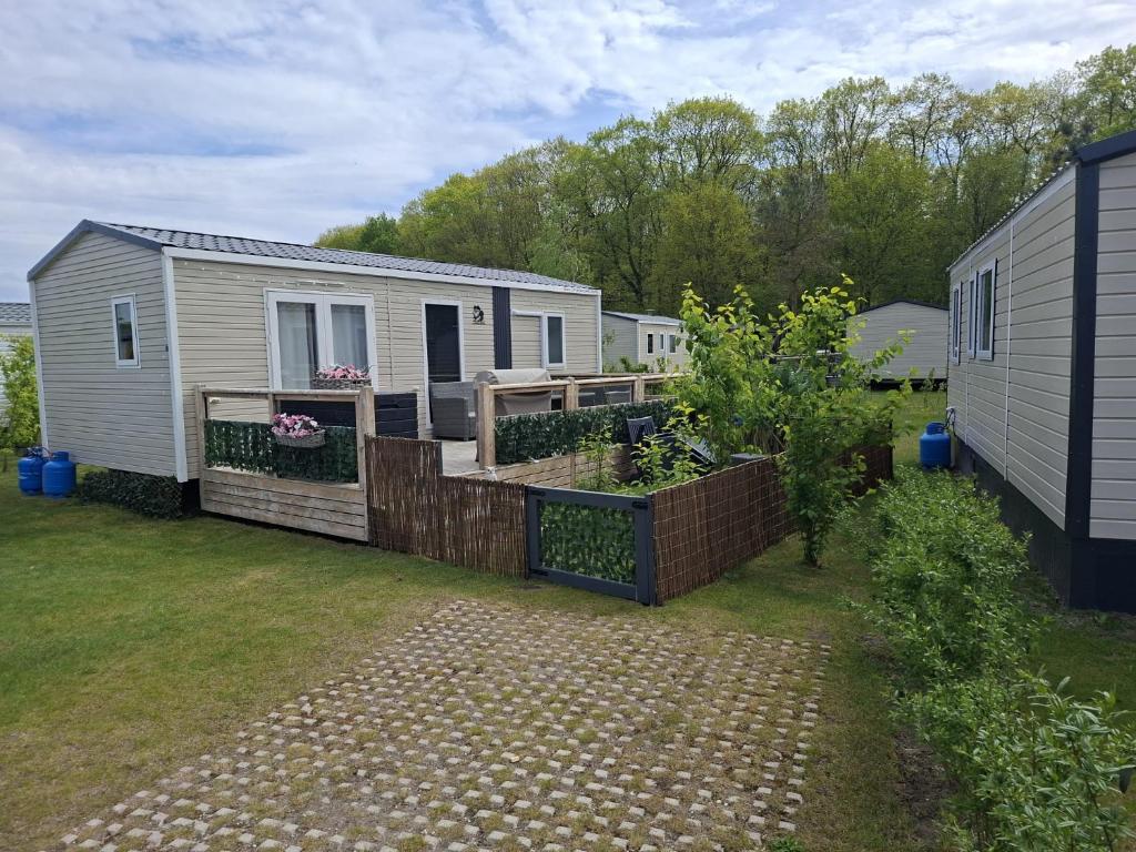 a tiny house in a yard with a fence at chalet bella in Gasselte