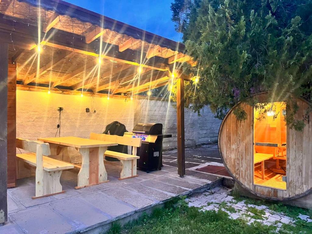 a patio with a wooden table and a wooden building at Вила Карапча in Stoyan Zaimovo