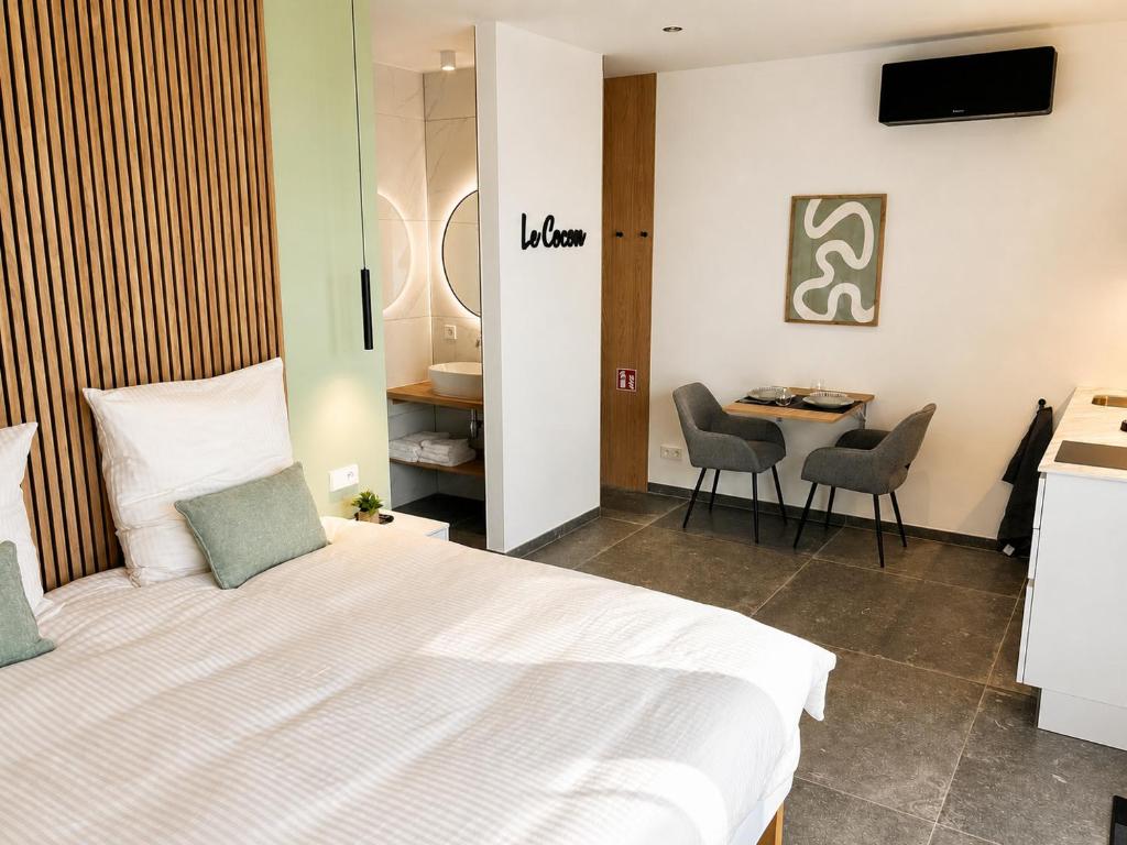 a bedroom with a bed and a table and chairs at Le Cocon Galhausen in Saint-Vith
