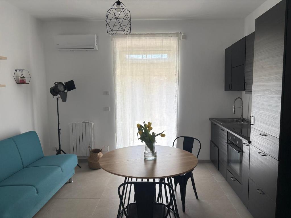 a living room with a table and a blue couch at Poggio sul Mare in Alberese