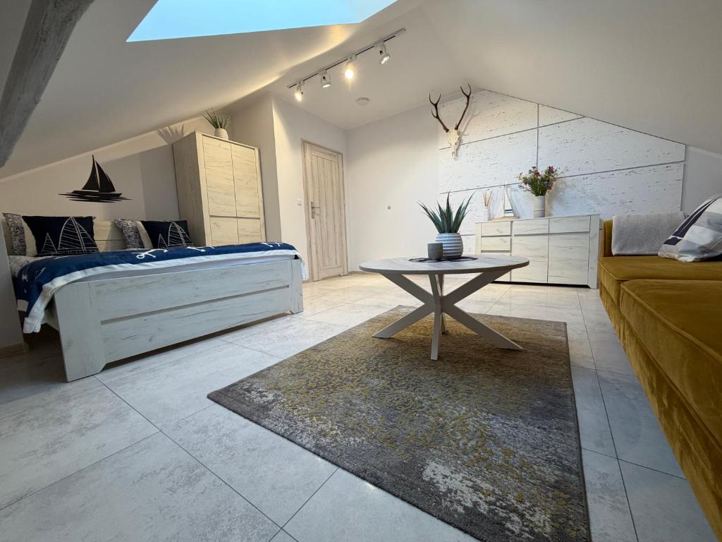 a bedroom with a bed and a table in a room at Poddasze Na Mazurach in Pisz