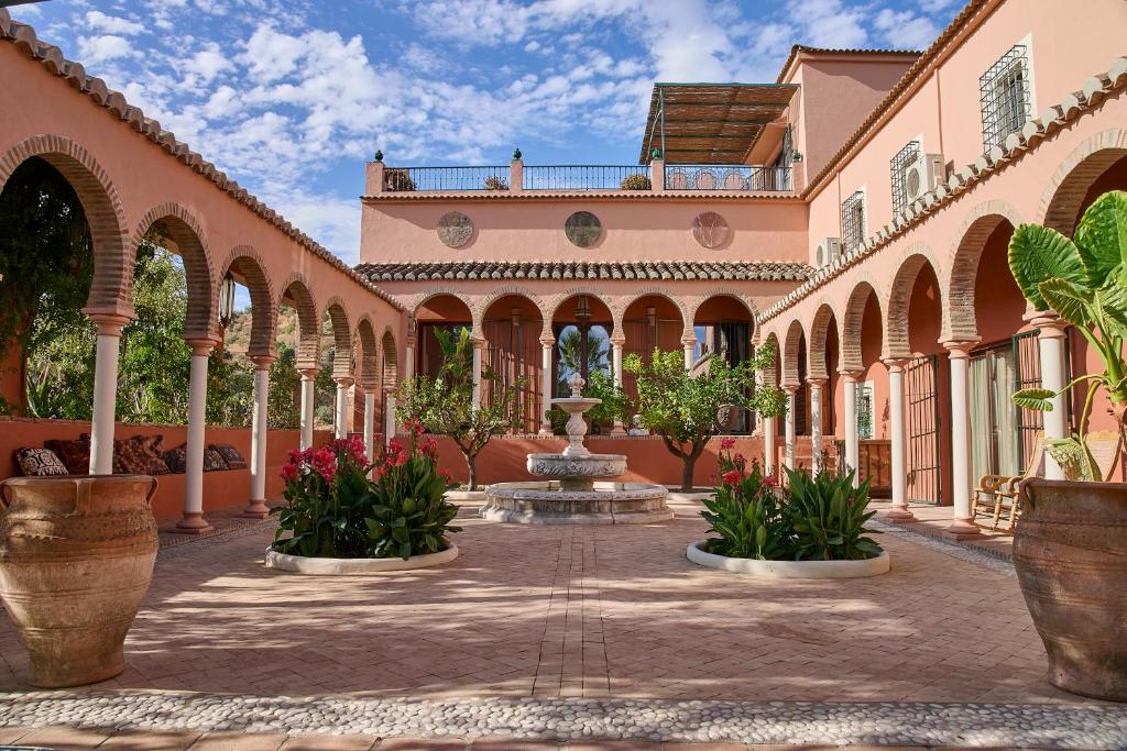 a courtyard of a building with a fountain and plants at Villa Camilla in Comares