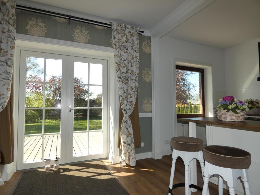 a room with a sliding glass door and two stools at fewo1846 - Romanze - idyllische Wohnung mit Garten im Grünen in Gelting