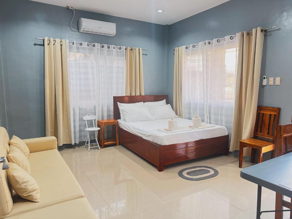 a bedroom with a bed and a couch at Pineda Villa in Puerto Princesa City