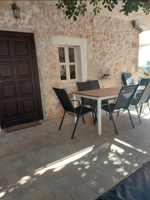 a table and chairs in front of a building at Apartmani Roko in Ražanac