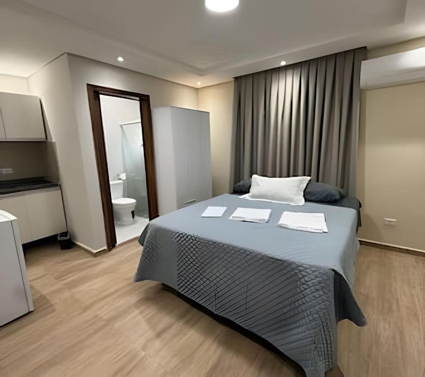 a bedroom with a large bed and a bathroom at Maryah Prime Studio Hotel Extrema + breakfast in Extrema