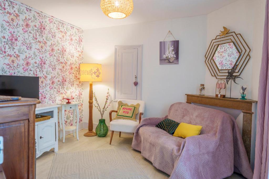 a living room with a chair and a tv at Jolie maison cosy in Saint-Uze