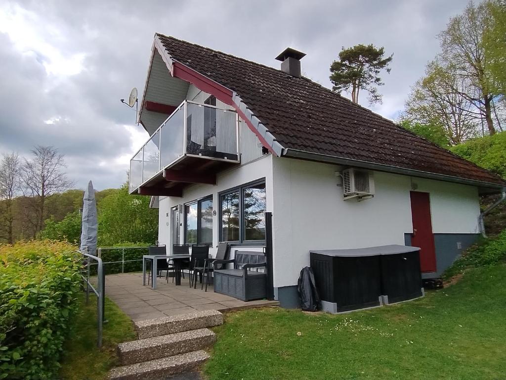 a white house with a balcony and a patio at Seeparkurlaub, Hessen in Kirchheim