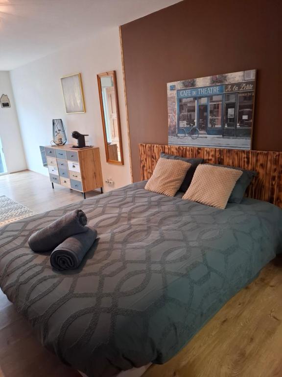 a bedroom with a large bed with two pillows on it at La parenthèse in Puy-dʼArnac