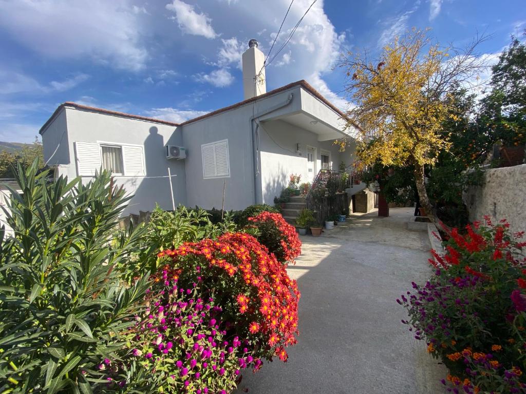 a white building with flowers in front of it at Canka Guest House in Përmet