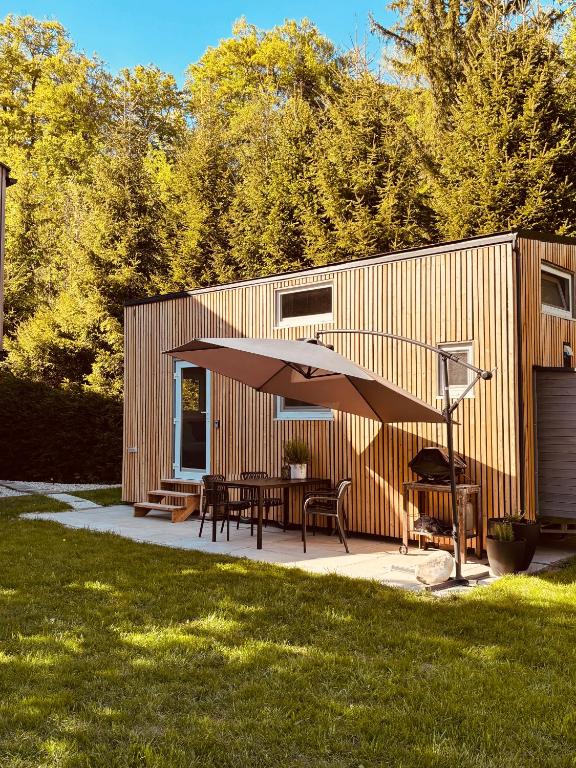 a patio with a table and an umbrella at Tiny House im Almtal in Pettenbach