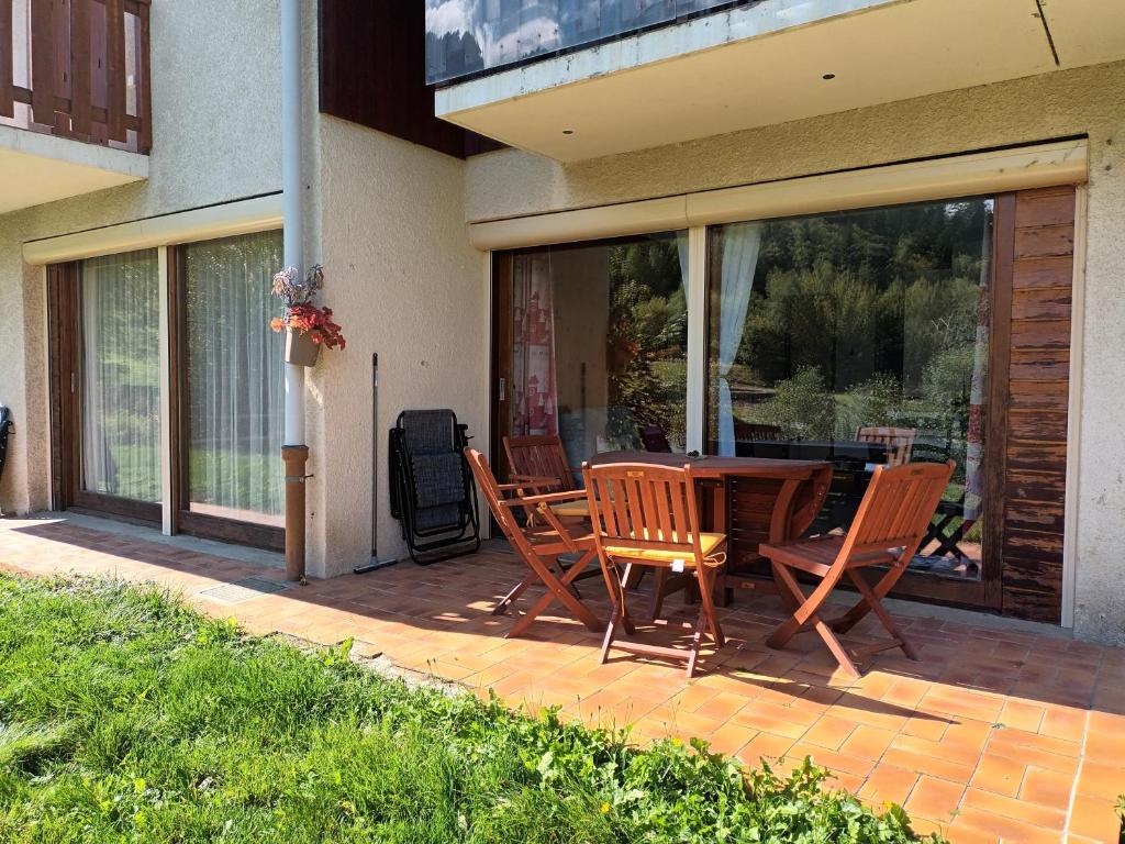 a patio with a table and chairs on a porch at Le Bochate in La Celle-sous-Gouzon