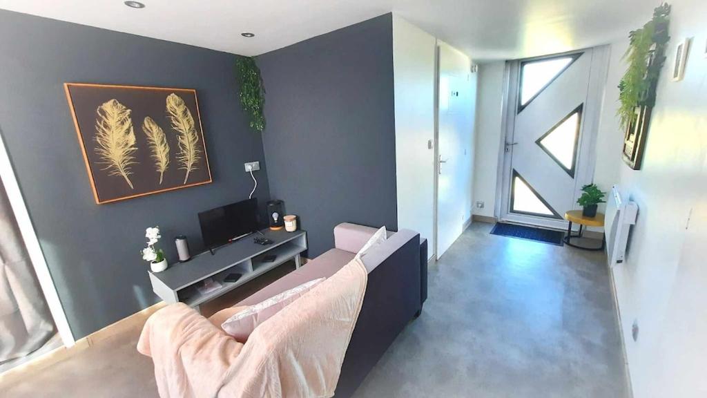 a living room with a couch and a tv at LIntemporel in Saint-Sornin