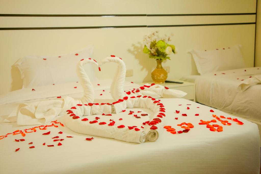 two swans made out of hearts on a bed at Mamush Hotel in Ārba Minchʼ