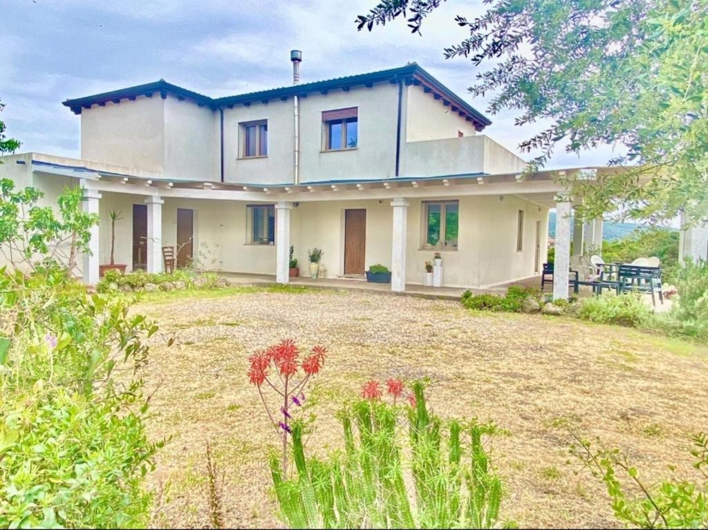 ein großes weißes Haus mit einem Vorgarten in der Unterkunft Alma Bed & Breakfast 15 minuti da Bosa e comodo parcheggio in Sennariolo