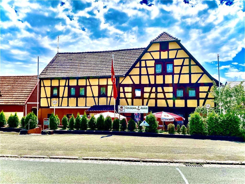 a large yellow building with a brown roof at Gasthaus Goldener Anker in Gemünden