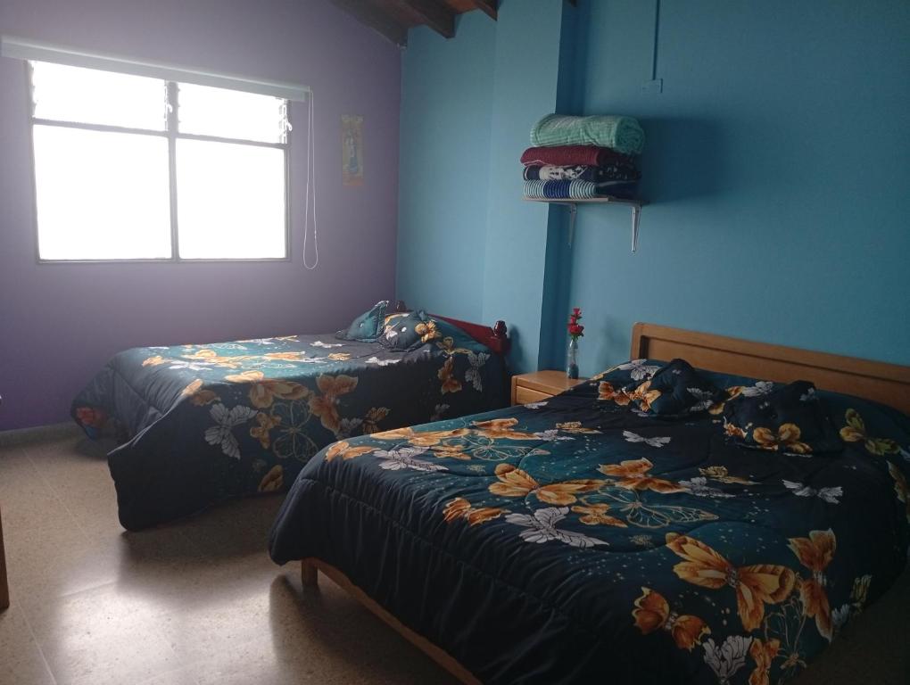 a bedroom with two beds and a window at Hotel la perla del pereira in Rionegro