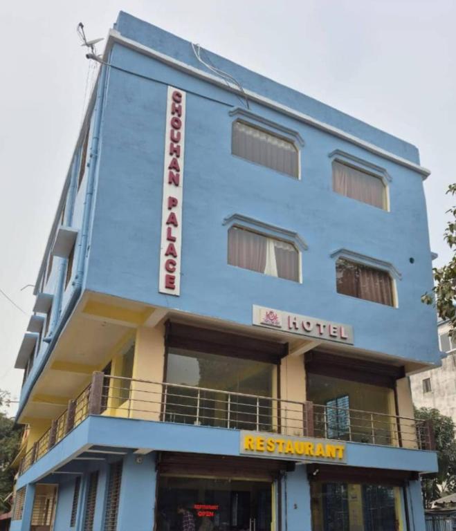 a blue building with a hotel sign on it at Chouhan Hotel in Katihār