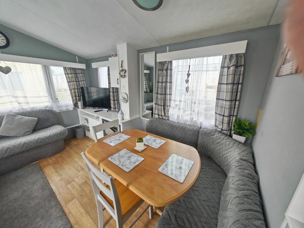 a living room with a table and a couch at 237 Sealands, 6 Birth caravan in Ingoldmells