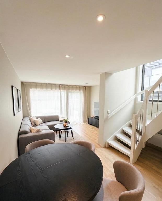 a living room with a couch and a staircase at Rekkehus i Sandnes in Stavanger