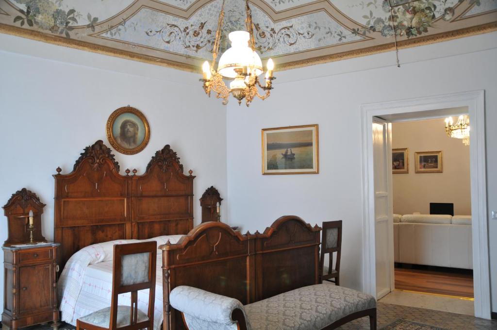a bedroom with a wooden bed and a chandelier at Casa Sipione Papa in Modica