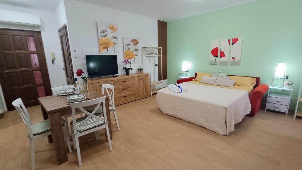 a bedroom with a bed and a table and a television at Sweet Simo House in Azzate