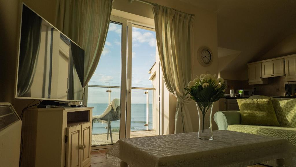 a living room with a view of the ocean at 2 bed Beachfront Apartment Inchydoney Cork in Cork