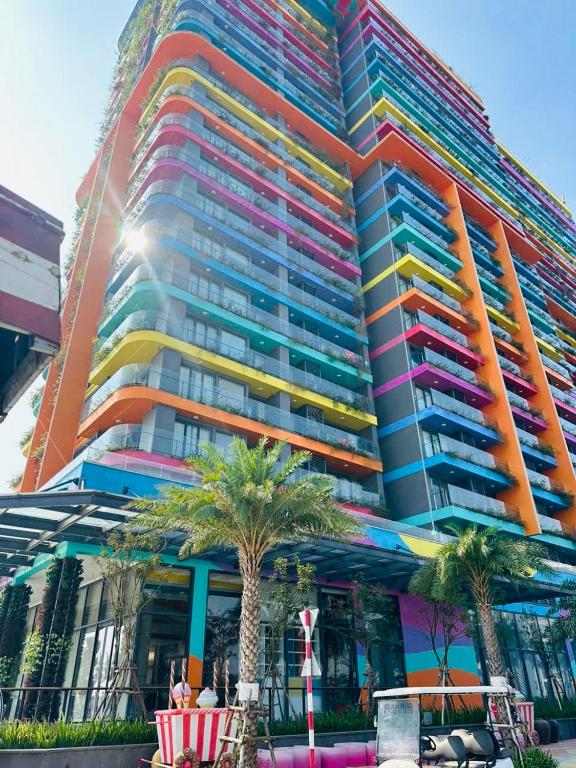 a large colorful building with palm trees in front of it at Flamingos Hải Tiến LUXURY view biển tầng cao và Biệt thự 4pn in Thanh Hóa