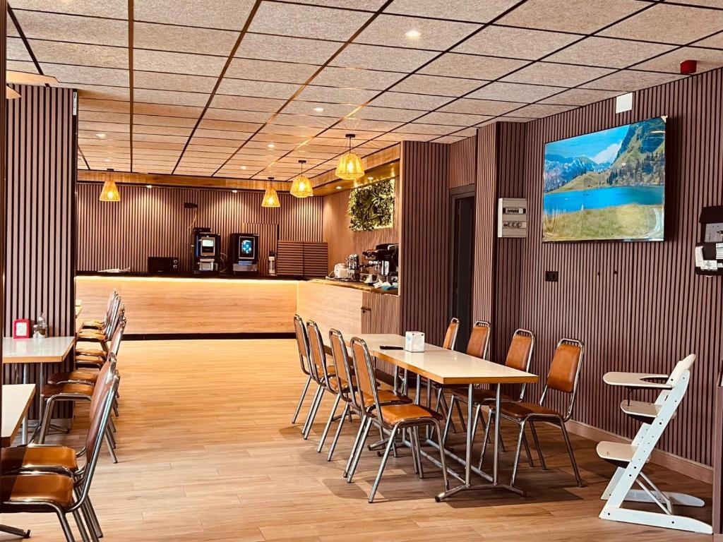 a restaurant with tables and chairs and a counter at Hotel Alain by Dynamic Hotels in Silla