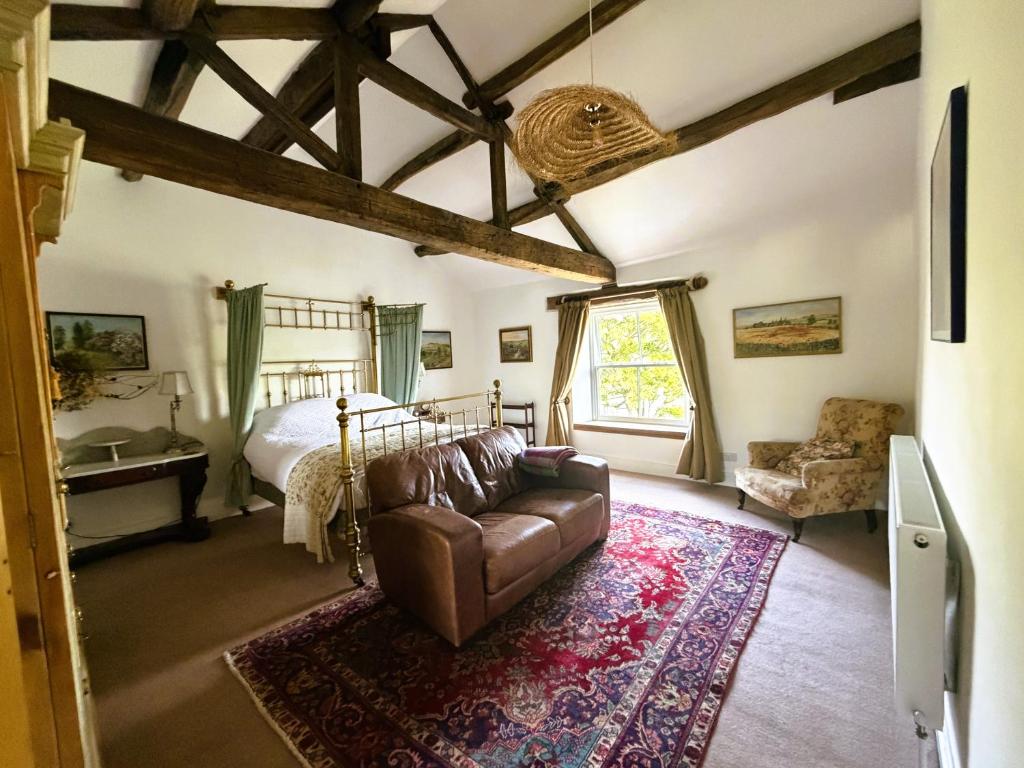 a living room with a couch and a bed at Burnlee House Apartment in Holmfirth