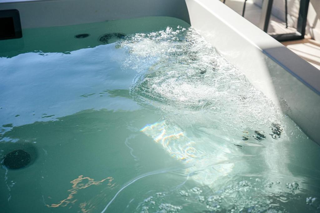 a person is splashing in a pool of water at Artion Jacuzzi Villa Nikiti in Nikiti