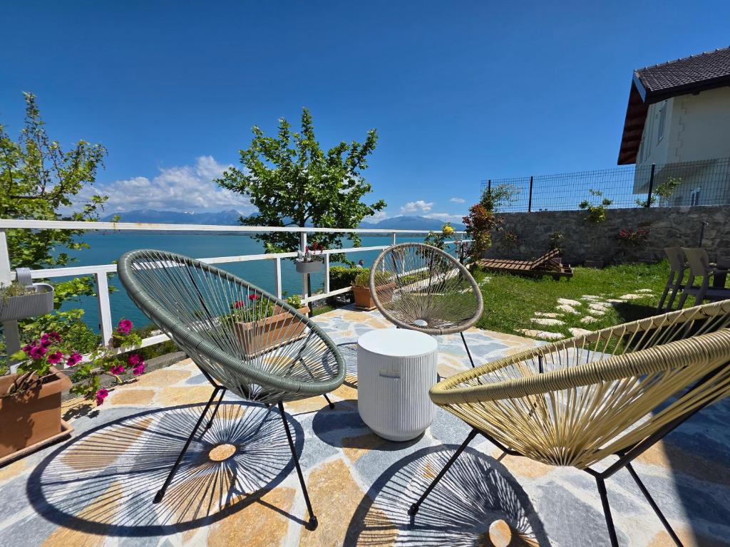 three chairs sitting on a patio with a view of the water at Pelikan Lake House in Shkodër
