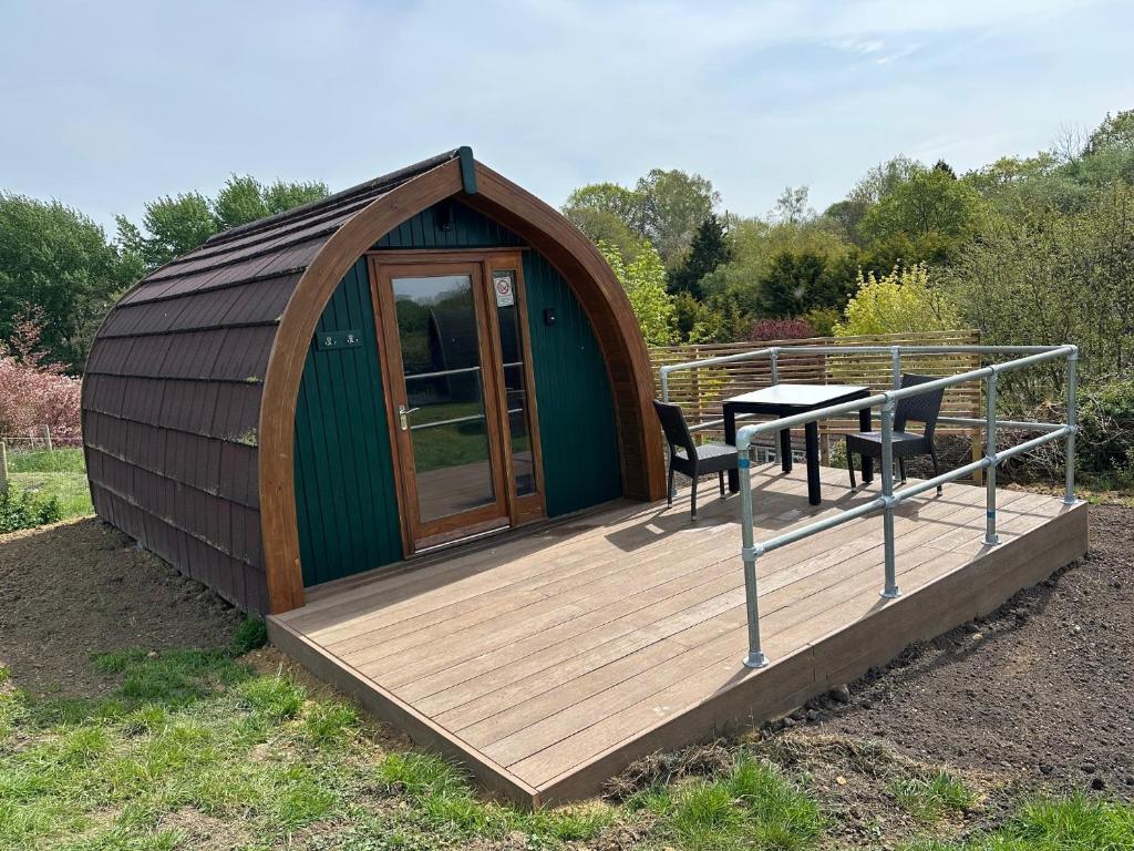 a gazebo with a table and a wooden deck at Rexes Hollow Camping in Yeovil Junction