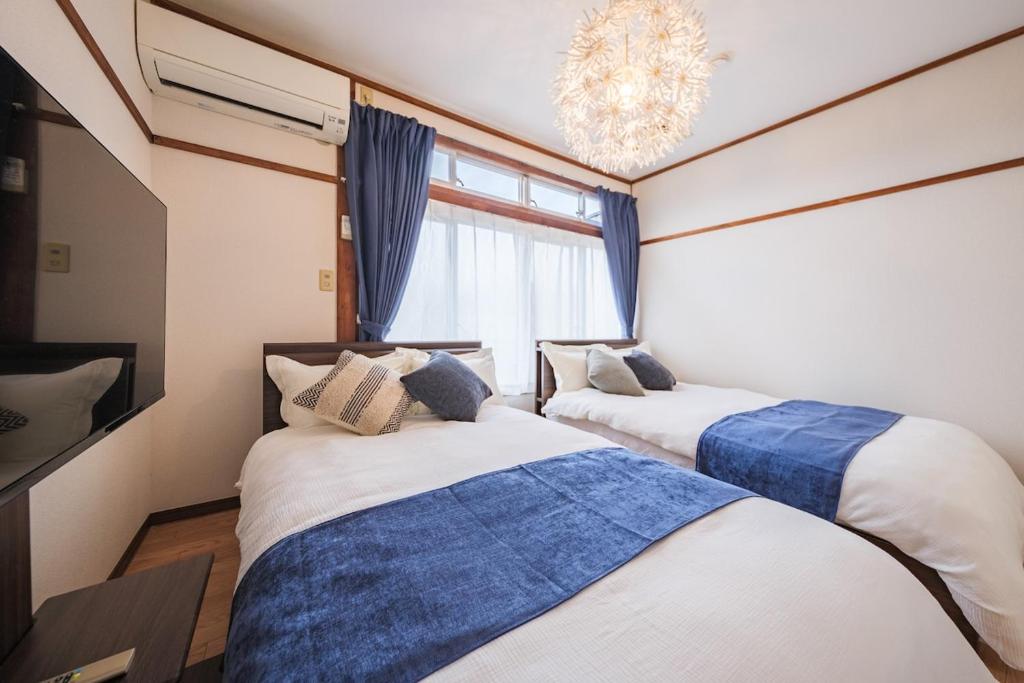 two beds in a room with a window at KEI HOUSE Yamato 202 in Yamato