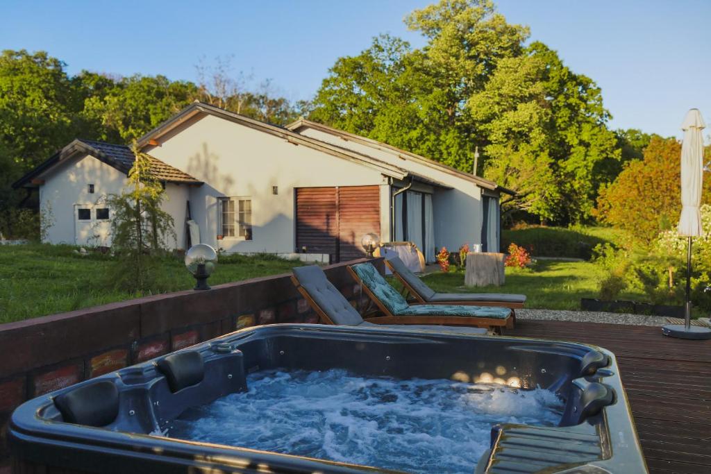a hot tub on a deck in front of a house at Gora Apartments by the Forest in Vrdnik