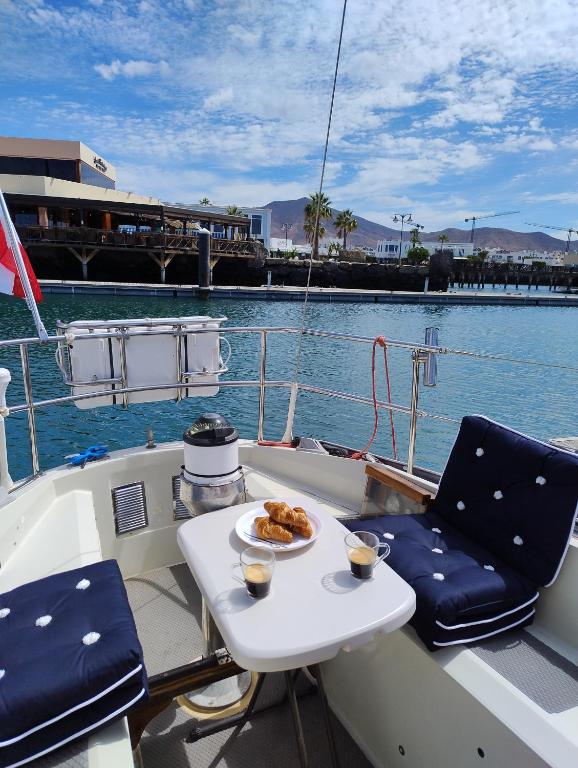 a table and chairs on a boat with a plate of food at Miramare in Playa Blanca