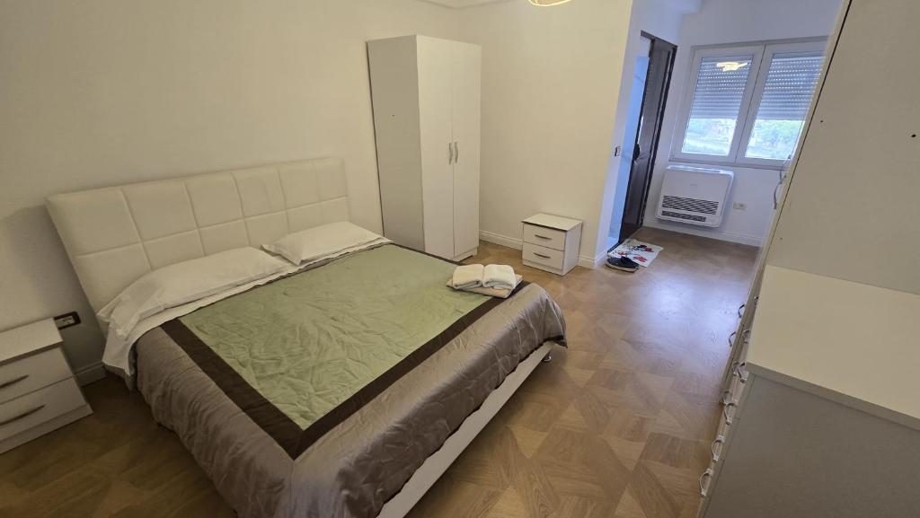 a bedroom with a large bed in a room at Grand House Apartment in Selitë e Vogël