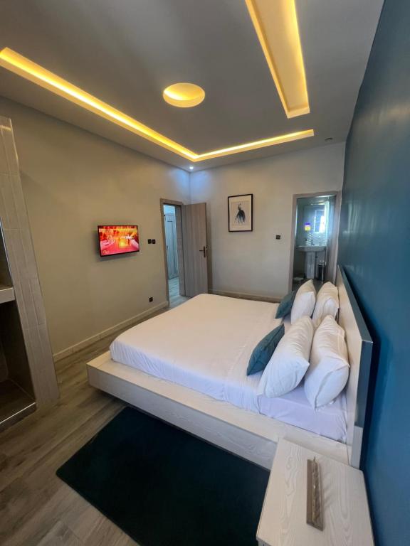 a bedroom with a large white bed with blue pillows at Welcome Home 102 SaintLouis in Saint-Louis