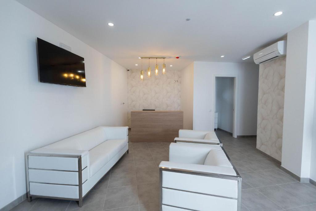 a living room with white furniture and a television at lovely cityscape in Lagos
